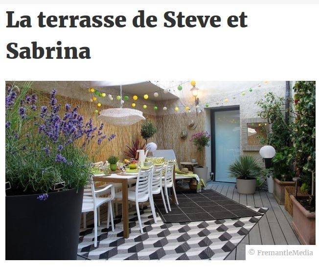 Terrasse équipée d'une table et fauteuils Grosfillex