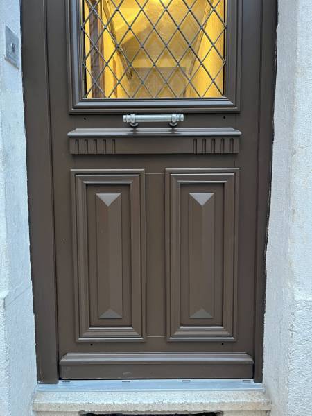 La porte Anne,  très travaillée avec sa cimaise crénelée et ses panneaux classiques pointe de diamant.